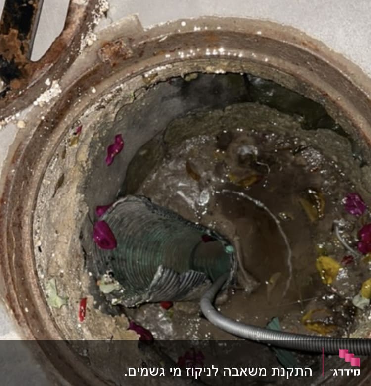 צינור מתכת בתוך פתח ביוב עם מים